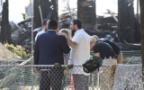 Le rabbin Yitzchok Lerman, qui a survécu avec sa famille à l'incendie qui a complètement détruit la synagogue Beth El, se tient devant les ruines de la synagogue à Rutherford, dans le New Jersey, le 8 août. (Crédit : Kyle Mazza/Anadolu via Getty Images via JTA)